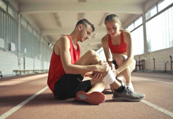 woman-helping-sportsman-with-injury-during-cardio-training-3760275-squashed